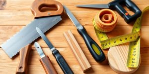 Collage of essential woodworking tools on a workbench.